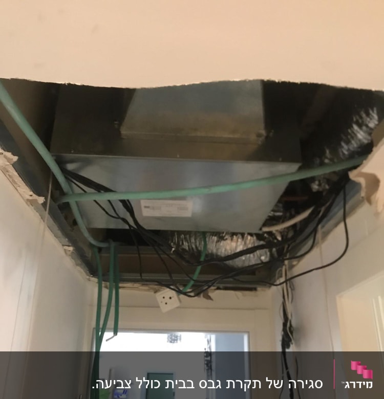 תקרה פתוחה עם חוטי חשמל וגבס חשוף